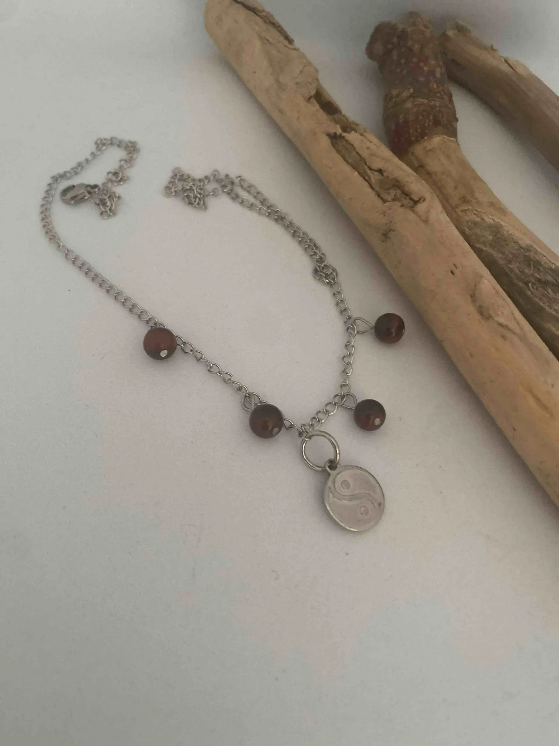 Collier en acier inoxydable composé d’une breloque yin et yang et de pierres naturelles oeil de taureau, œil de taureau