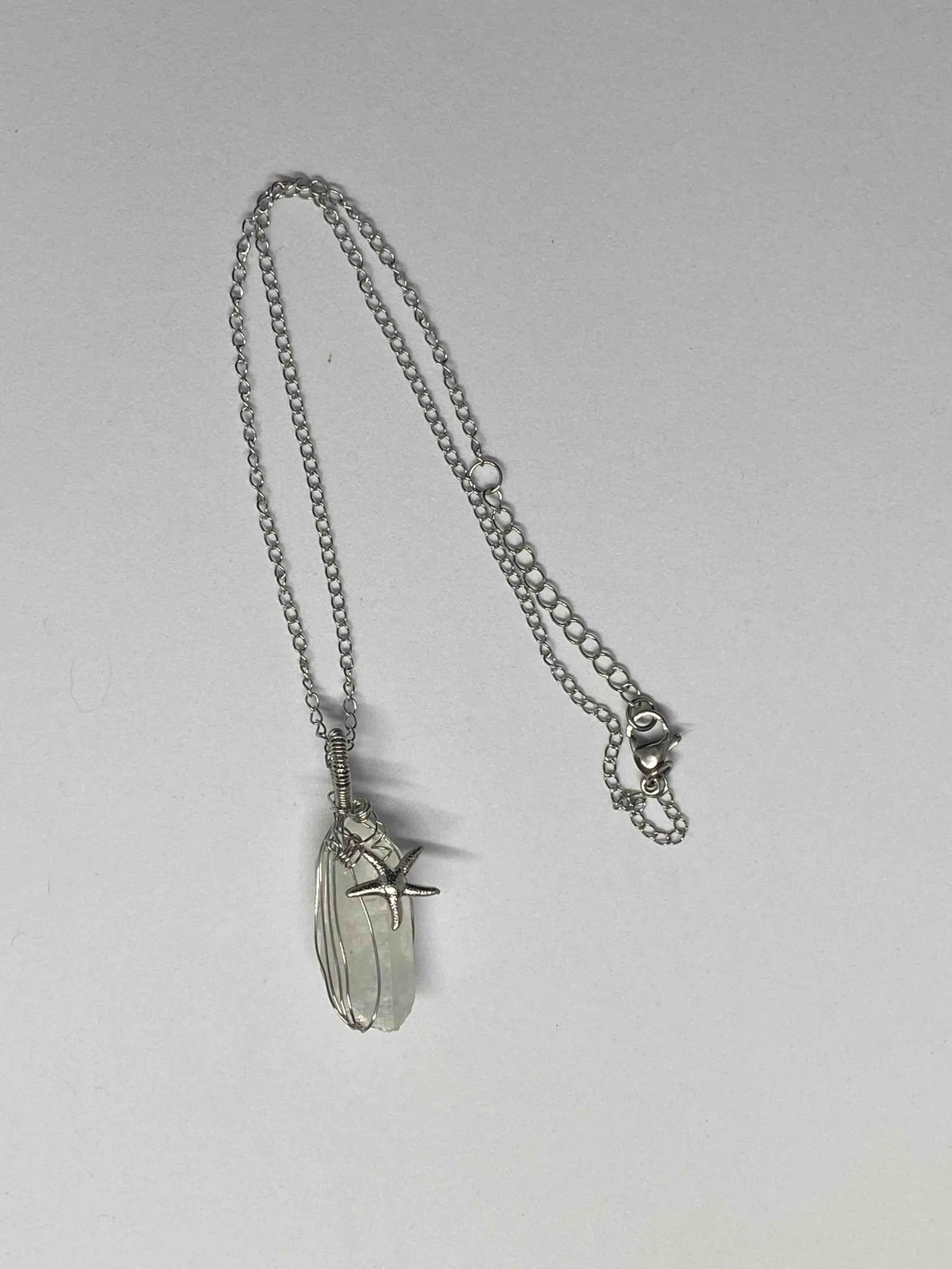 Collier composé d’une pierre naturelle de cristal de roche et d’une étoile de mer, cristal de roche